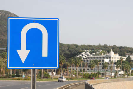 U turn road sign on a metal pole against the backdrop of residential development, Alanya November 2021の写真素材