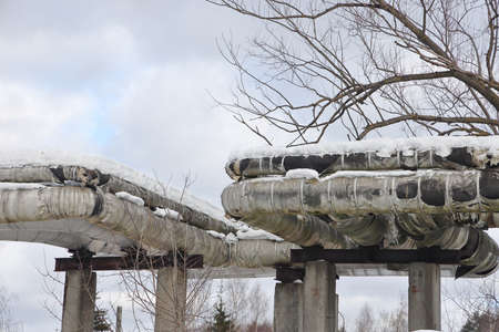 The main provides the city with hot water. selective focus. The large pipes of the central heating system are covered with snow. fuel crisis. Increasing the cost of heatingの写真素材