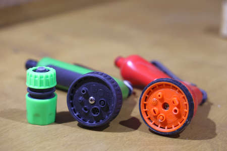 Gardener holding hand hose sprayer and watering plants in gardenの写真素材