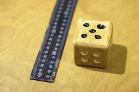 wooden dice and metal ruler, handmade dice, selective focus. unpredictability