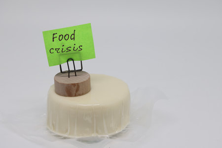 A round piece of cheese in a package and a sticker that says world food crisis