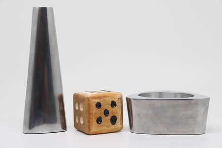 Metal figures and a dice, cold stability and wooden unpredictability, opposites
