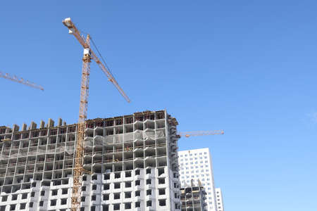 Construction of new residential high-rise buildings. Against the background of a yellow sunset sky
