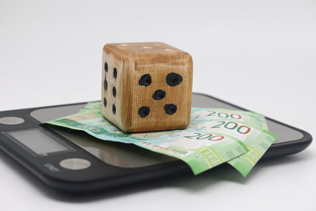 Wooden dice with the Word FAQ on dollar banknotes background. Concept of economy and frequently...