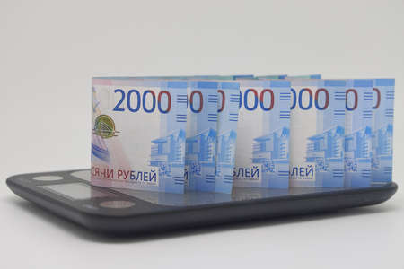 Banknotes on electronic kitchen scales, financial accounting and planning, family budgetの写真素材