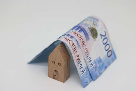 the toy house is covered with banknotes, own home insurance, mortgage, a symbol of material well-beingの写真素材