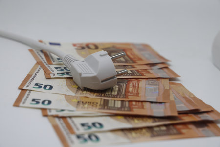 White electric cable and banknotes, expensive electricity, saving electricityの写真素材
