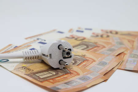 White electric cable and banknotes, expensive electricity, saving electricity