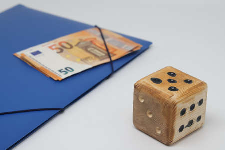 Wooden spmodel cube on the background of banknotes. The concept of the unpredictability of the...