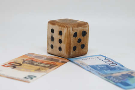 Homemade dice lies on banknotes, unpredictability of financial markets.の写真素材