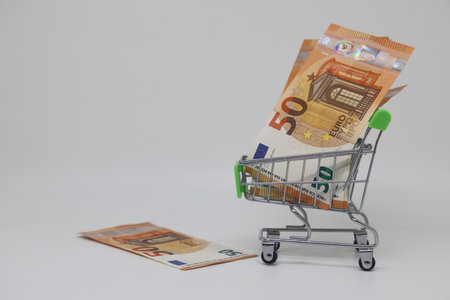 Toy cart grocery and banknotes, shopping for goods, exchange rate volatilityの写真素材