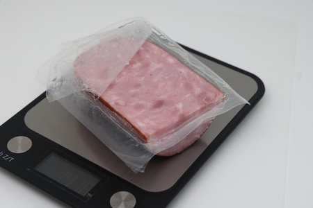 Sliced boiled delicious sausage on electronic scales, calorie counting, proper nutrition