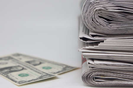 Rolled up stack of newspapers, banknotes stuck between newspapers, news, fake news, corrupt press