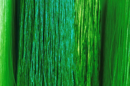 Side view of red, blue and orange thin hanging threads, changed color scheme, colorful background