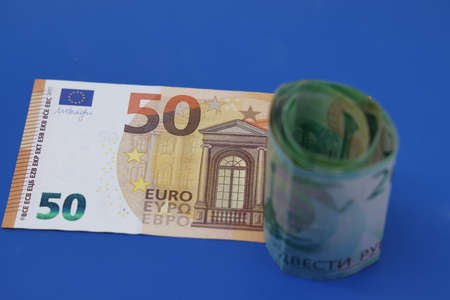 Russian rubles on the background of euro banknotes. The concept of the exchange rate, sanctions, the fall of the ruble. money conceptの写真素材