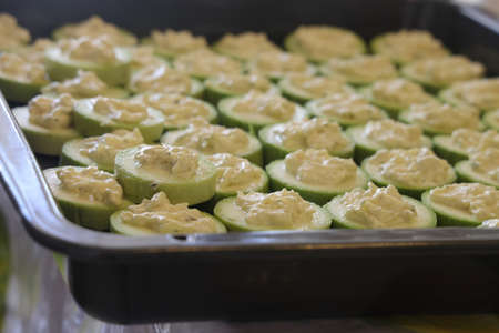 zucchini on a baking sheet on a dark background ready for baking, top view. healthy food concept