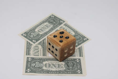 The dice lies on banknotes laid out in the shape of a house. The volatility of the housing market. the concept of buying, selling, renting, creditの写真素材