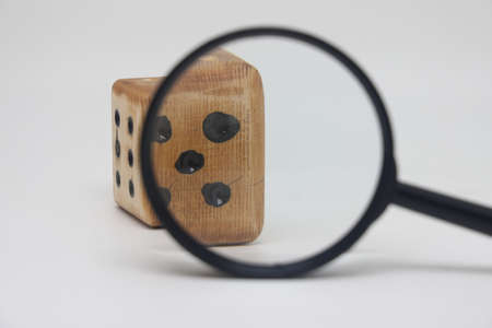 Dice through a magnifying glass, profit and revenue unpredictability, plan a marketing strategyの写真素材