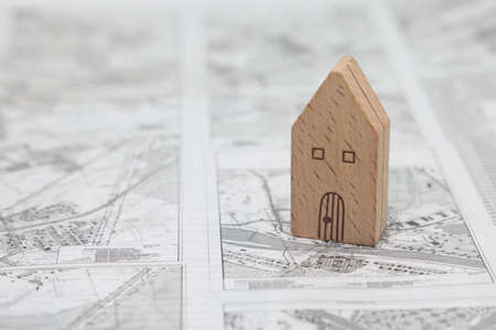 Wooden model house stands on the scheme of land plots, real estate purchaseの写真素材