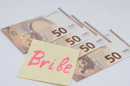 Banknotes in a yellow envelope on a light background. envelope with banknotes. international currency banknote. Bribery, corruptionの写真素材