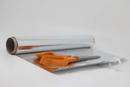 Metal food foil cut into strips and scissors. For sharpening scissors in everyday lifeの写真素材