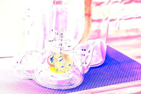 lemon in a glass teapot on the kitchen table. Winter holidays concept. Changed color scheme. colorful backgroundの写真素材