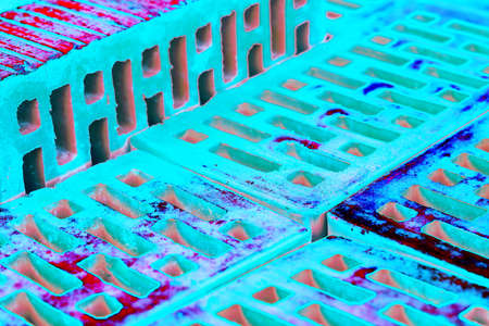 Stack of red bricks for construction, hollow brick. Material for construction and repair. Changed color scheme. colorful abstract backgroundの写真素材