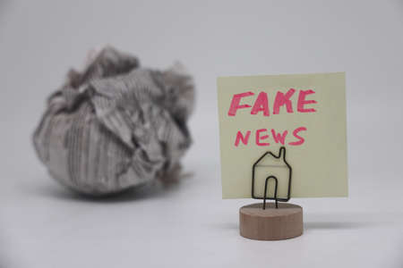Banknote on the background of a crumpled piece of newspaper on a white background, fake news, corrupt journalismの写真素材