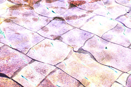 Background of glare of sunlight in a fountain with a stone bottom. Changed color scheme. colorful...