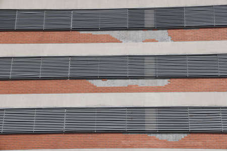 Fragmet of the facade of a multi-storey car park on a summer day. Multi-storey parking, minimalism,...