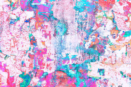 Empty bulletin board with scraps of old advertising posters and newspapers. Changed color scheme. Colorful abstract background.の写真素材