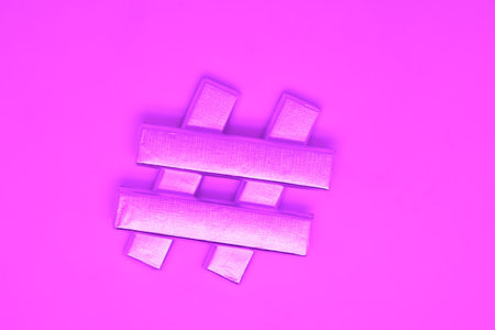 Hash tag number sign made of candies in a silver wrapper on a purple backgroundの写真素材