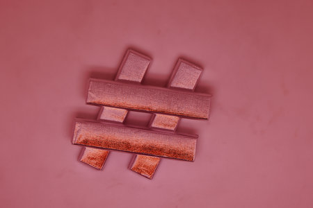 Hash tag number sign made of sweets in a silver wrapper on a light background. Changed color schemeの写真素材