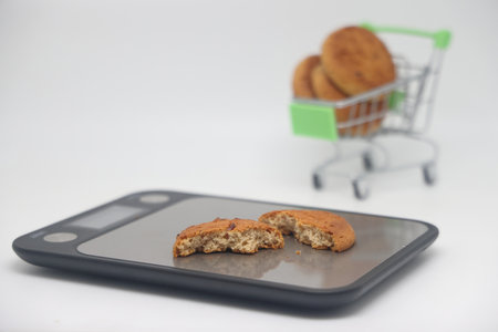 A pack of cookies on an electronic kitchen scale, accurate calorie counting, proper nutrition, dietの写真素材