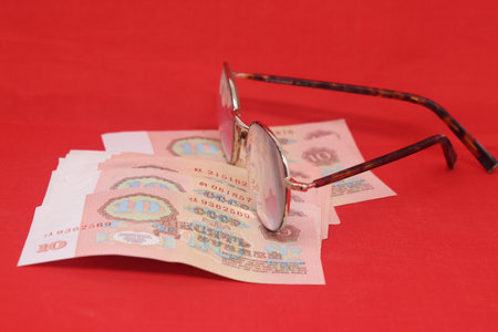 Pair of glasses and money on a red background. Selective focus.. Old banknotes of the former Soviet Union. USSR - rublesの写真素材