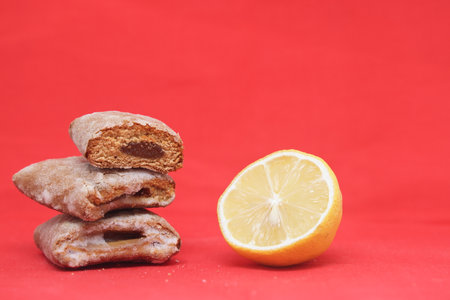 Lemon and gingerbread cookies on a red background with copy space. Sugar-coated gingerbread cookies...