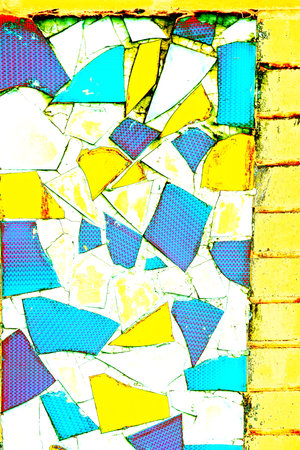 abstract background of an old wall with pieces of colored broken glass