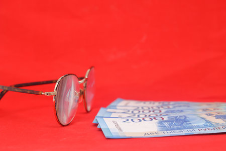 Pair of glasses and money on a red background. Selective focus.. Old banknotes of the former Soviet Union. USSR - rublesの写真素材