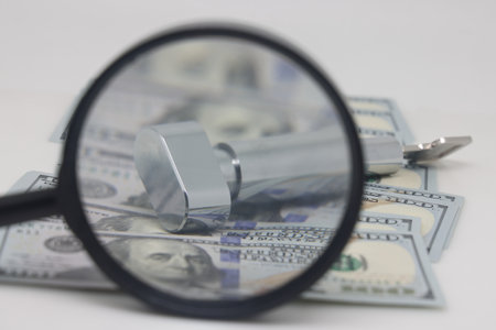Dollars, door lock mask and magnifying glass on a white background, real estate purchase. selective focusの写真素材
