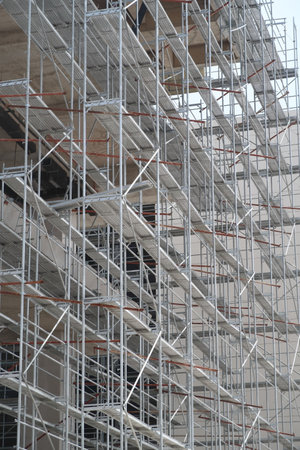 Scaffolding on multi storey building facade during facade renovation. bright sunny day
