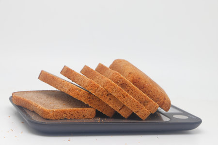 Sliced black bread lies on an electronic kitchen scale on a white background. diet and proper...