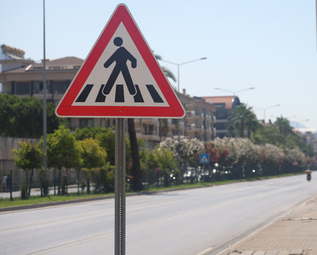 a busy highway with a curb in the city with green spaces and a dividing metal meshの写真素材
