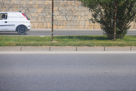 A section of an asphalt road with a curb stone and a lawn, minimalism, urbanism.の写真素材