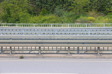Asphalt road section with curbstone and highwayの写真素材