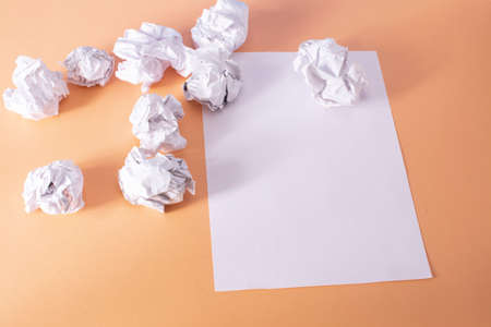 Sheet of paper and crumpled paper balls top view