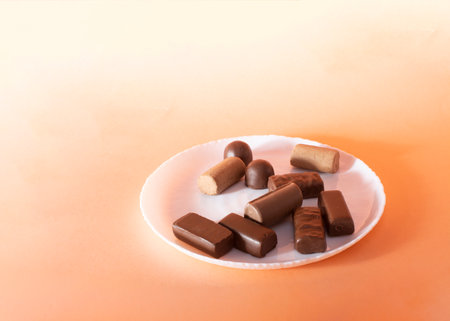 chocolate candies in a plate on a colored backgroundの写真素材