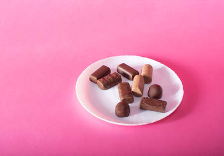 chocolate candies in a plate on a colored backgroundの写真素材