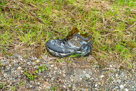 dirty krasovki ripped and torn on the groundの写真素材