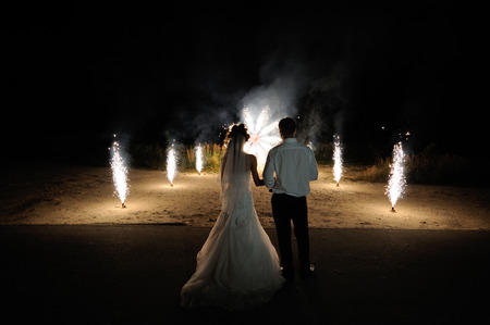 Bride and groom on the background of wedding fireworks.の写真素材