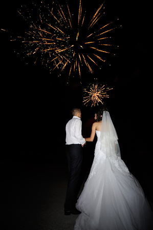 Bride and groom on the background of wedding fireworks.の写真素材